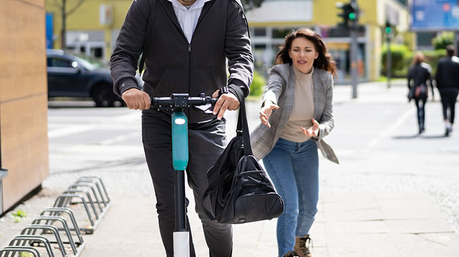 womans purse being snatched by man on bike